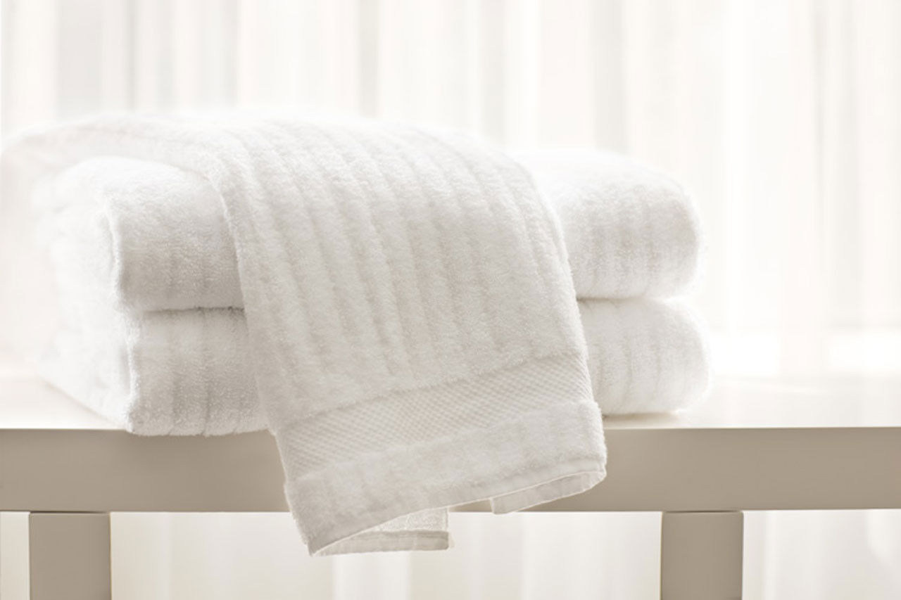 Can you specify the material used in the production of the luxury striped bath towels?