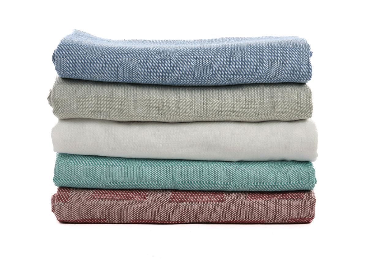 In what colors is the Polyester Spread Blanket available?