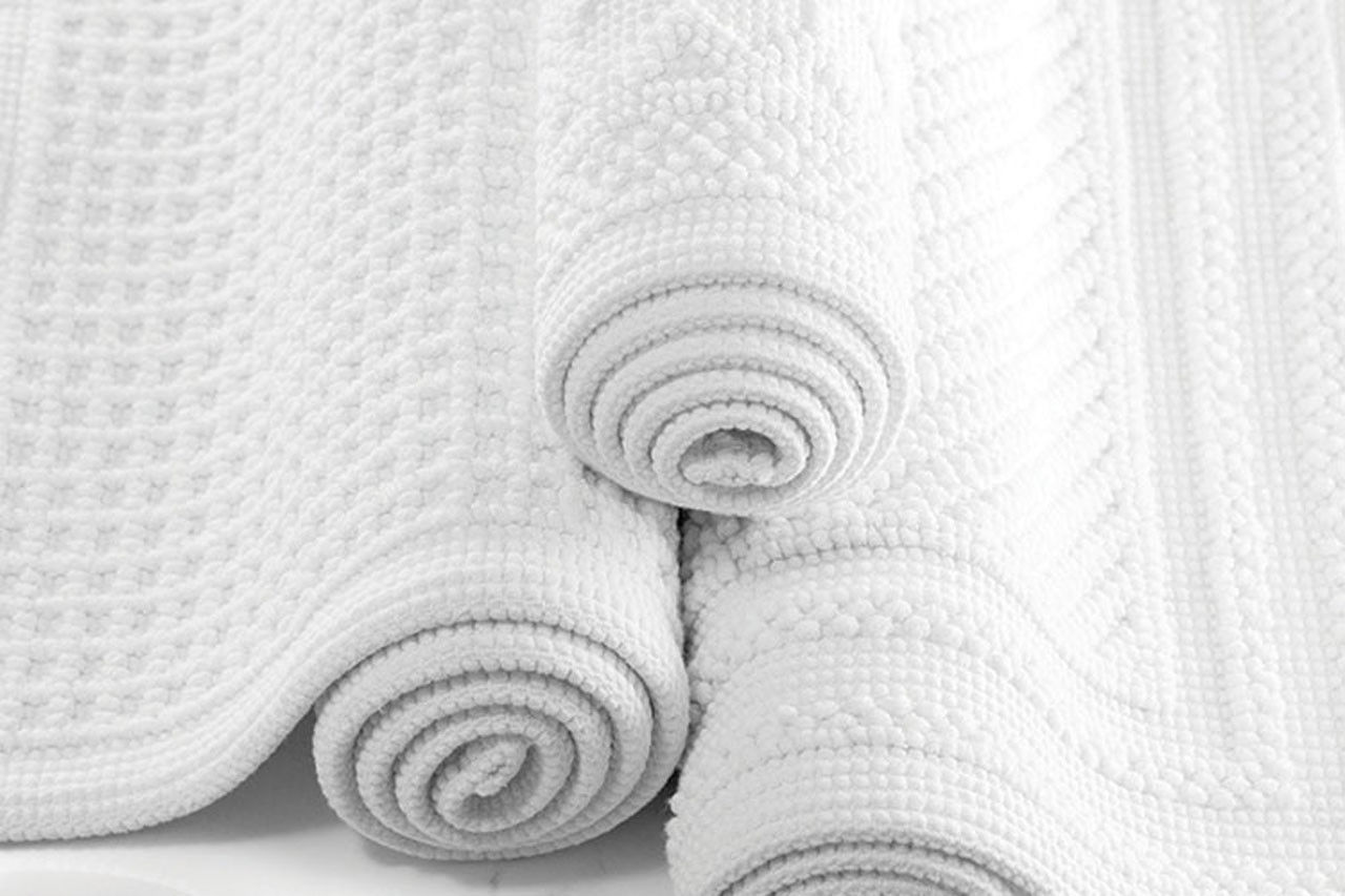 What fabric is the Artesano bath mat made from?